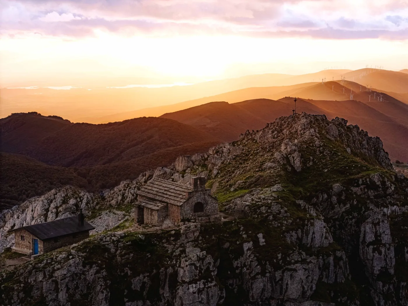 Fotografía aérea al atardecer de la ermita y el refugio en la cima del monte Aizkorri